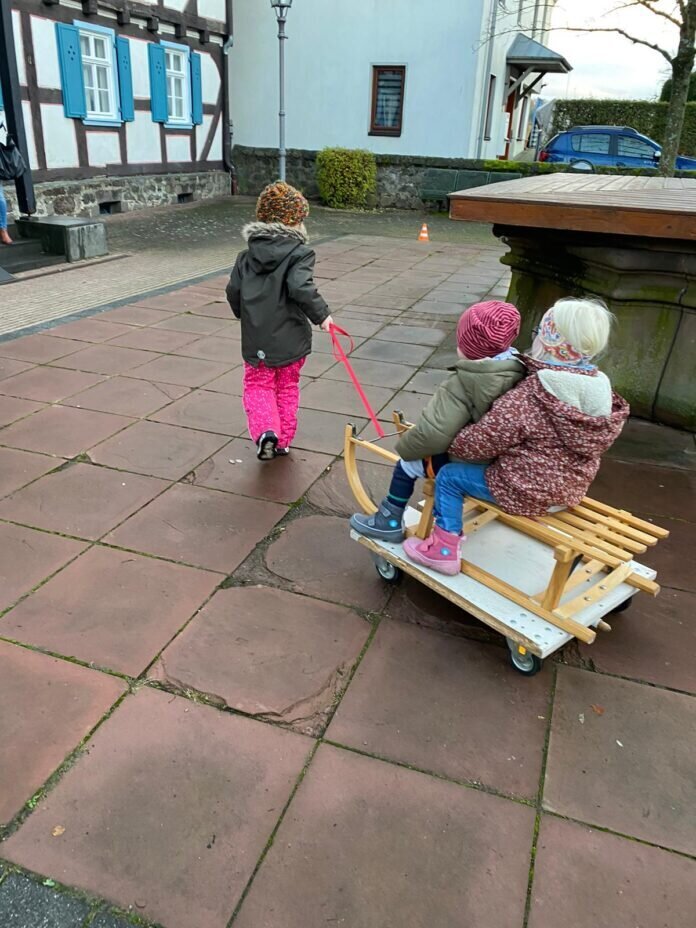 Kinder beim „Schlitten fahren“ am Winterplatz