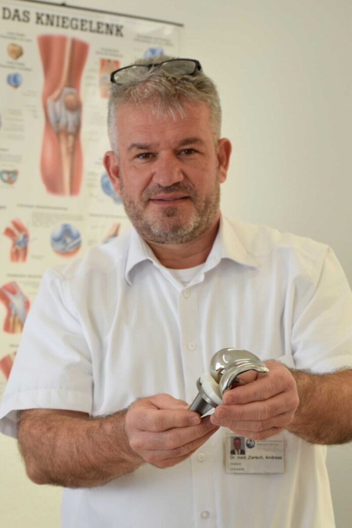 Dr. med Ziersch zeigt ein künstliches Gelenk
